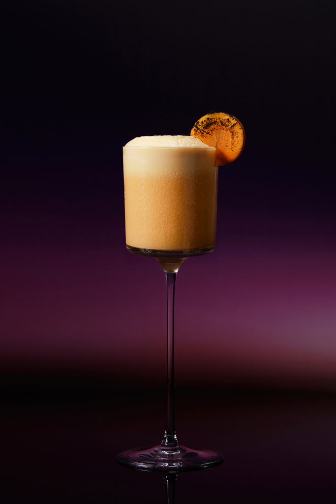 Colorful cocktail in a glass, photographed against a dark background