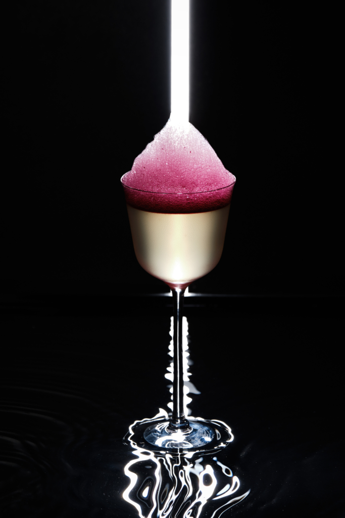 Colorful cocktail in a glass, photographed against a dark background