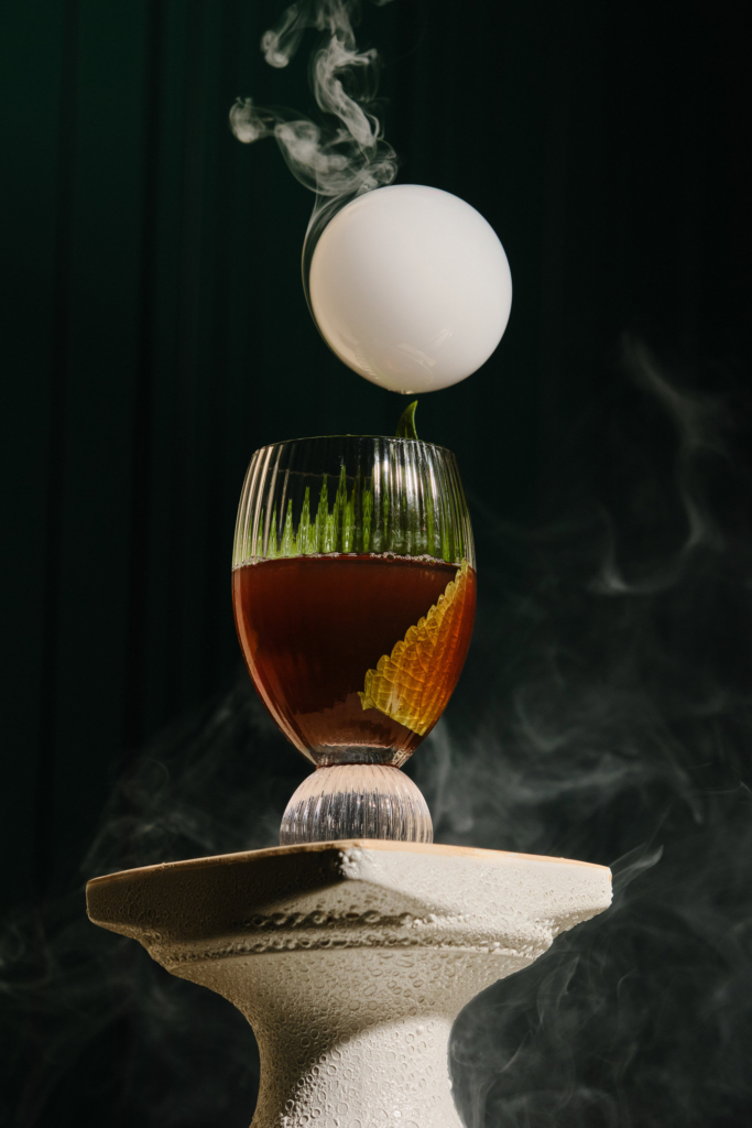 Colorful cocktail in a glass, photographed against a dark background