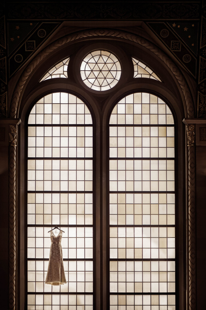 Every year I choose a select number of images to enter into the WPPI 16x20 International Print Competition. Judged every spring at the annual convention in Las Vegas the print competition pushes me to create stronger images that tell a clearer story. This image won First Place in the Wedding Details category in 2014 and I am extraordinarily proud of this photograph. I was photographing a bride getting ready at a synagogue on the Upper East Side in Manhattan and I was struggling with finding a good location to take a clear, beautiful picture of the bride’s wedding dress. I saw these gorgeous arched windows in the synagogue and wished that I could put the dress in the window - and then I saw the balcony. Very, very carefully and with the help of my assistant I climbed the stairs to the balcony and hung the dress in the window. Was it dangerous to climb up there? Possibly. But was so, so very worth it.