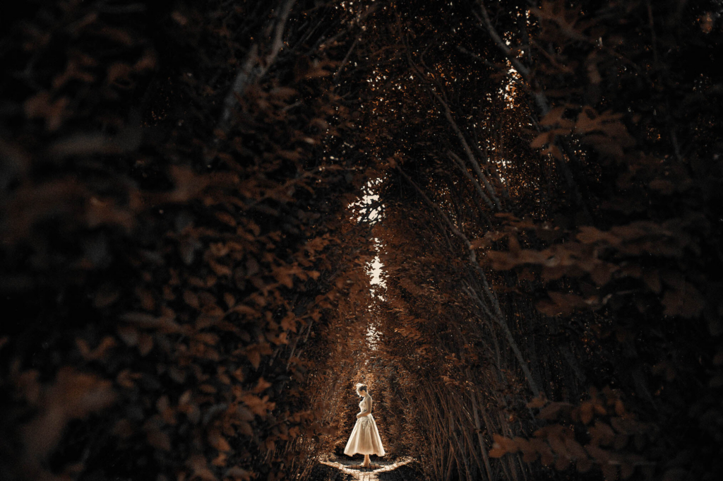I love every single thing about this portrait and the bride in it. In 2013 I traveled to Cape Cod to photograph a wedding at a private home by the water on the Cape and it was wonderful to explore somewhere that I’d never photographed a wedding before. I got to the home early that day to scout the location and was immediately drawn to a towering thicket and the narrow tunnel that cut through it. I knew that I wanted to use that space for some portraits and I hoped that the beautiful light would carry on through the day so that I could use it beautifully when the time came to shoot in that location. The bride and groom saw each other for the first time that wedding day at 3:00pm and in June the light is still strong, bright, and almost directly overhead. I know that if I used that location for a portrait the light would be coming down hard right on top of the bride’s head. I had the bride tip her head downwards so that the pose was more serene and also so that the light would cover her entire birdcage veil. I absolutely love this portrait. I entered it into the 2014 WPPI 16x20 International Print Competition and was thrilled with my final score! It also hung in the background for the 30 Days of Wedding Photography course that I taught for Creative Live in the spring of 2014.