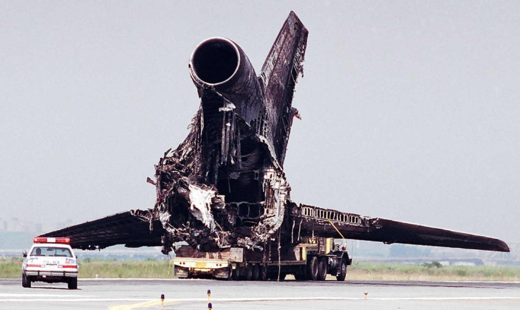 Workers remove the remains of a Lockheed L-1011 TriStar airplane that caught fire while departing for San Francisco and aborted the takeoff shortly after liftoff. There were no fatalities among the 280 passengers, although the aircraft was destroyed.