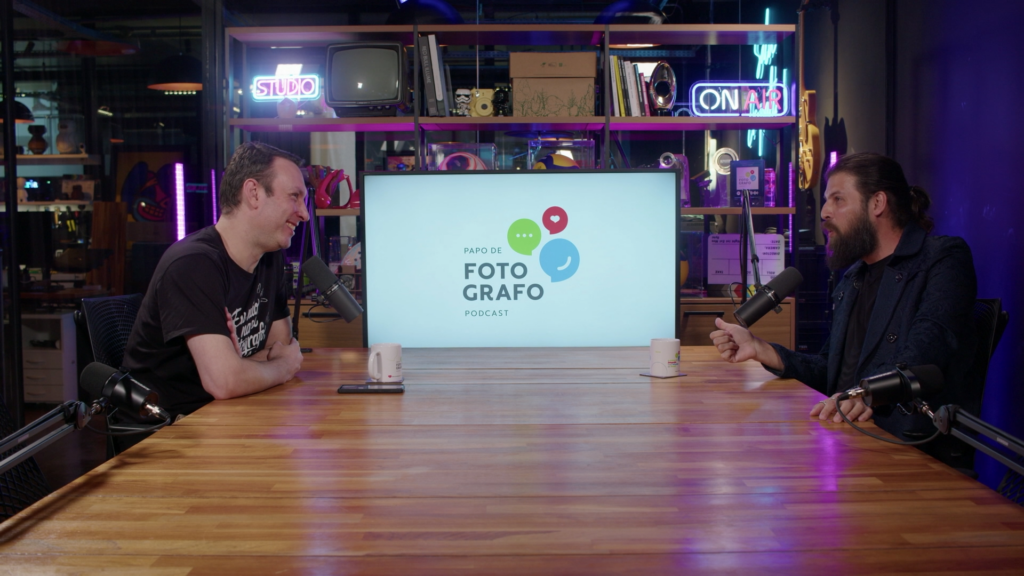 Podcast- A conversation takes place in a studio setting, with people seated and speaking into microphones or engaging in an interview.