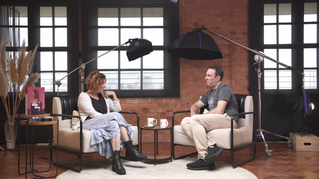Podcast- A conversation takes place in a studio setting, with people seated and speaking into microphones or engaging in an interview.