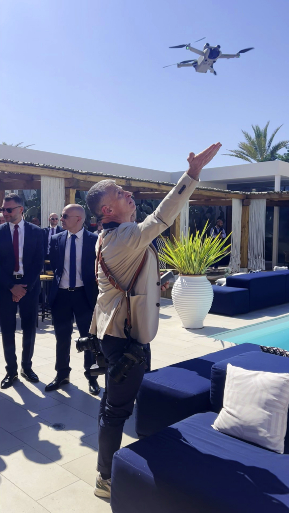 Wedding photographer David using a drone to capture aerial footage during an outdoor event.