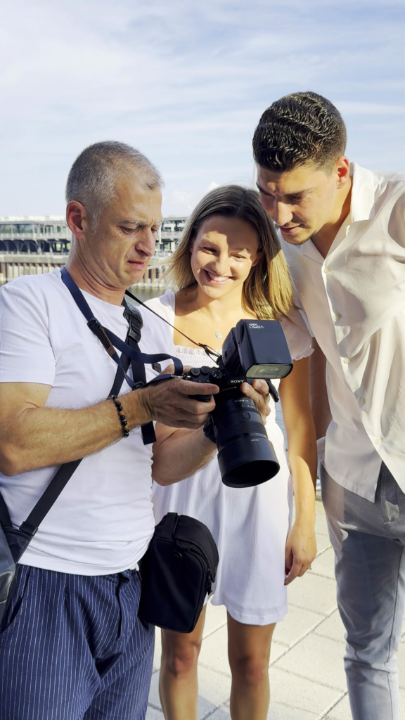 Photographer showing and capturing candid wedding moments with a couple outdoors by the sea.