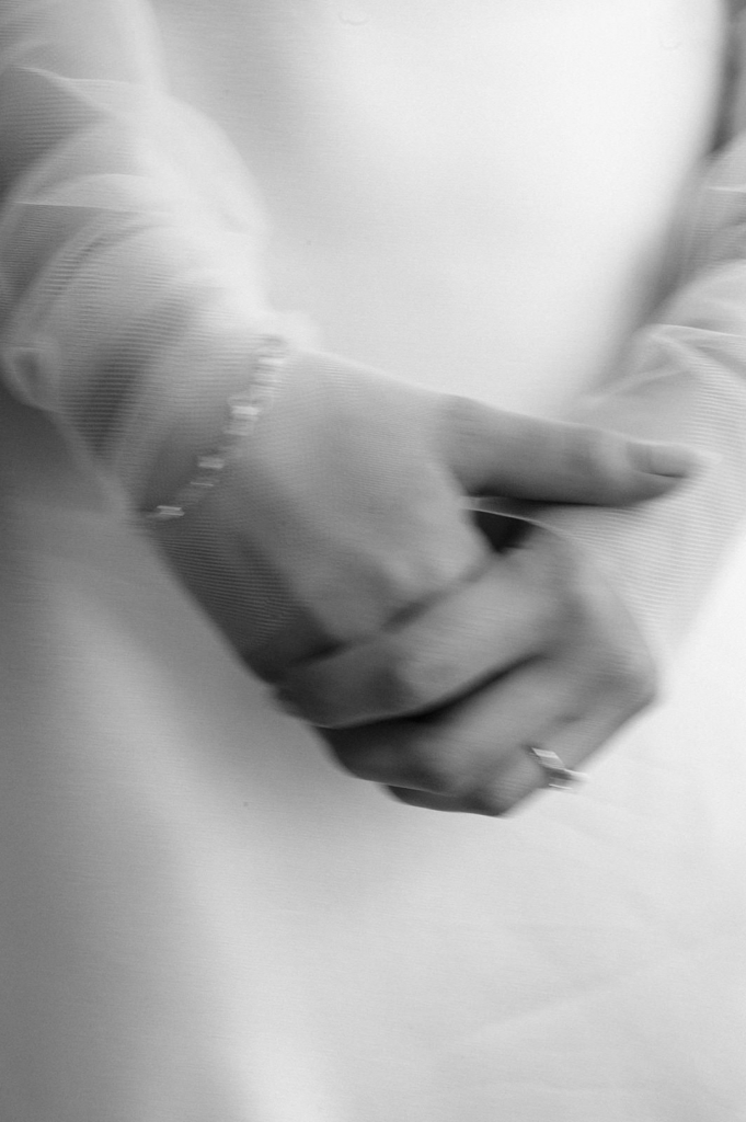 A close-up of two hands gently holding each other, with soft focus and subtle motion blur.