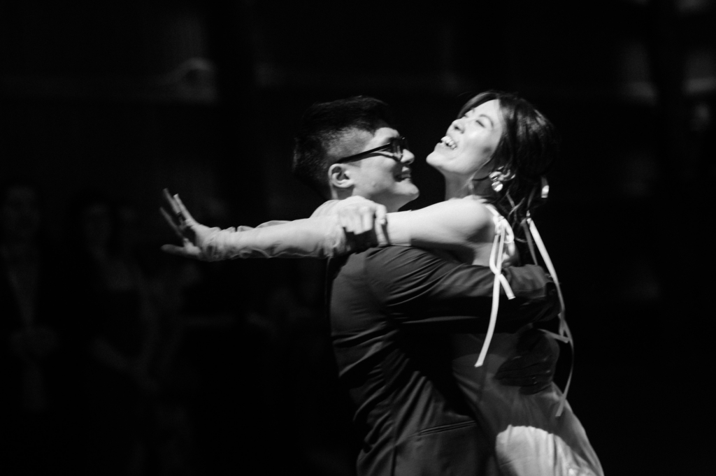 A close-up of a couple dancing, the groom holding the bride as she leans back with her arms outstretched in a joyful moment.