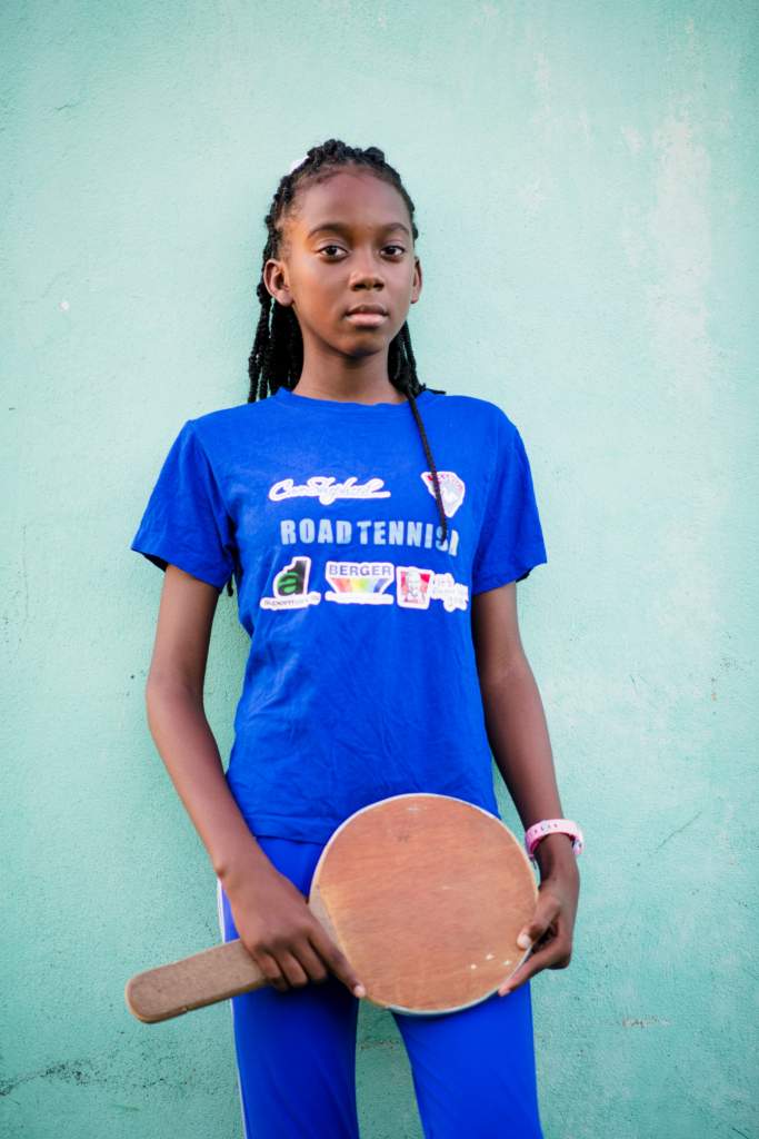 Portrait of a young table tennis player holding a paddle during the Girls in Sport documentary photography project in Barbados.
