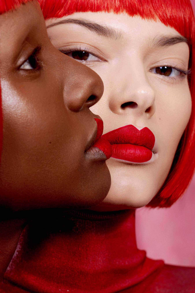 Bold beauty portrait with graphic red styling and intimate facial composition.